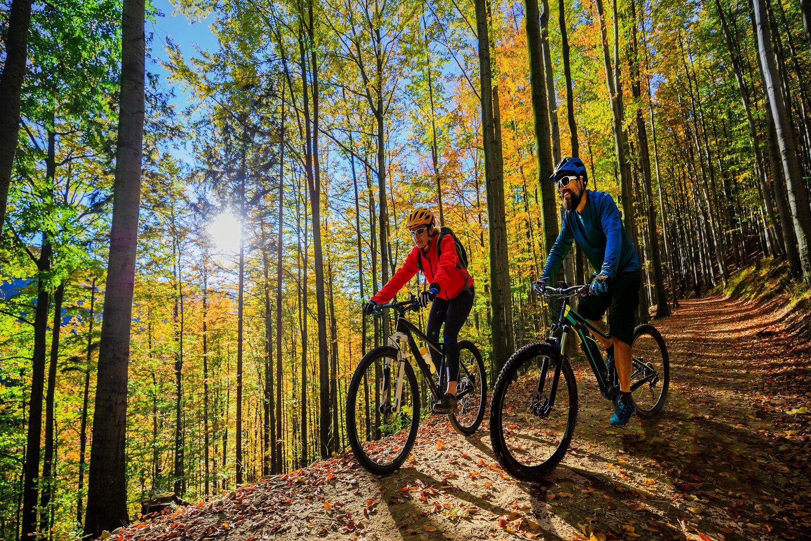 Cycling,Woman,And,Man,Riding,On,Bikes,At,Sunset,Mountains