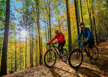 Cycling,Woman,And,Man,Riding,On,Bikes,At,Sunset,Mountains